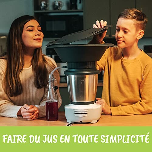 Deux personnes utilisant une machine à jus dans la cuisine.